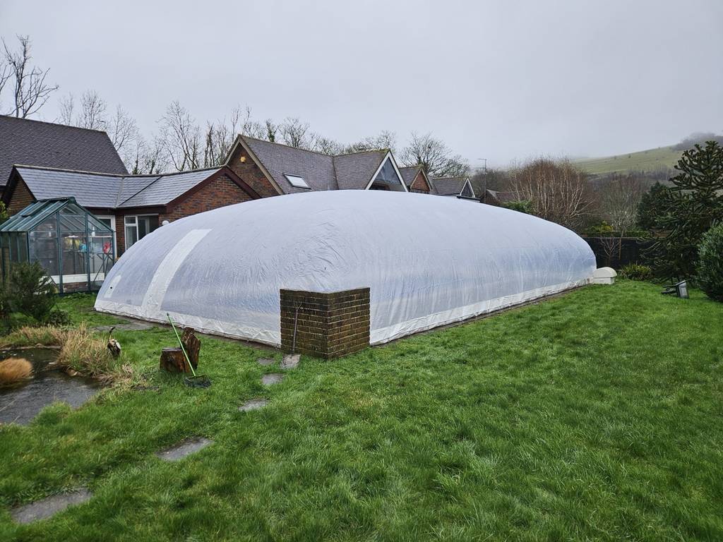 Fully installed inflatable pool dome in a UK backyard, covering a swimming pool for year-round use and protection from the weather.
